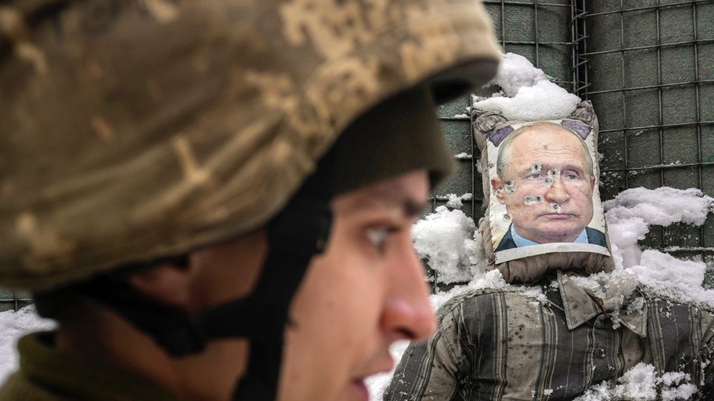 Seorang tentara Ukraina, dengan latar belakang gambar Presiden Rusia Vladimir Putin, dalam wawancara dengan media di front depan pertempuran di wilayah Luhansk, Ukraina timur, 1 Februari 2022.