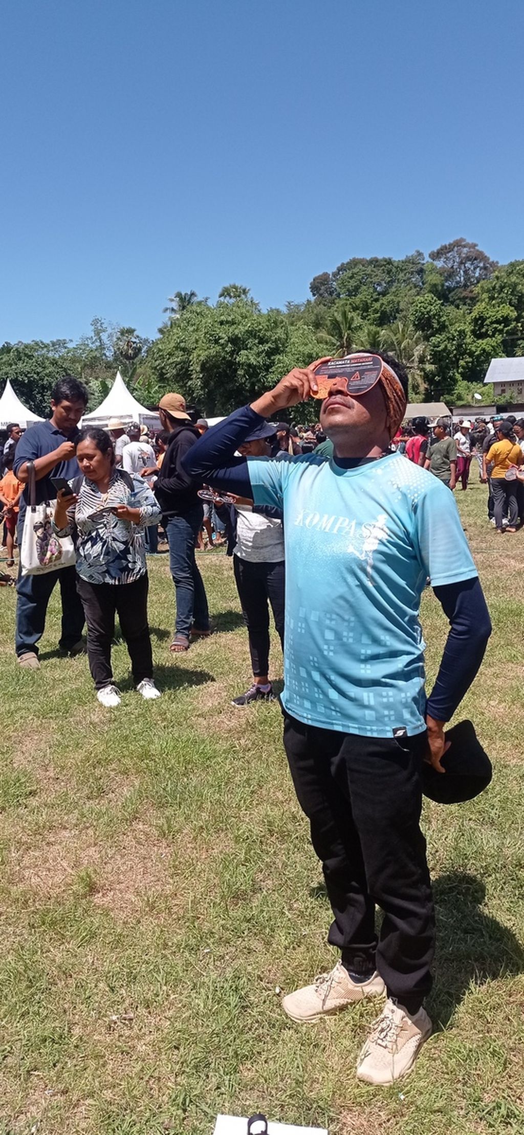 Jurnalis <i>Kompas,</i> Frans Pati Herin, saat meliput momen gerhana matahari total di Pulau Kisar, Maluku, Kamis (20/4/2023). 
