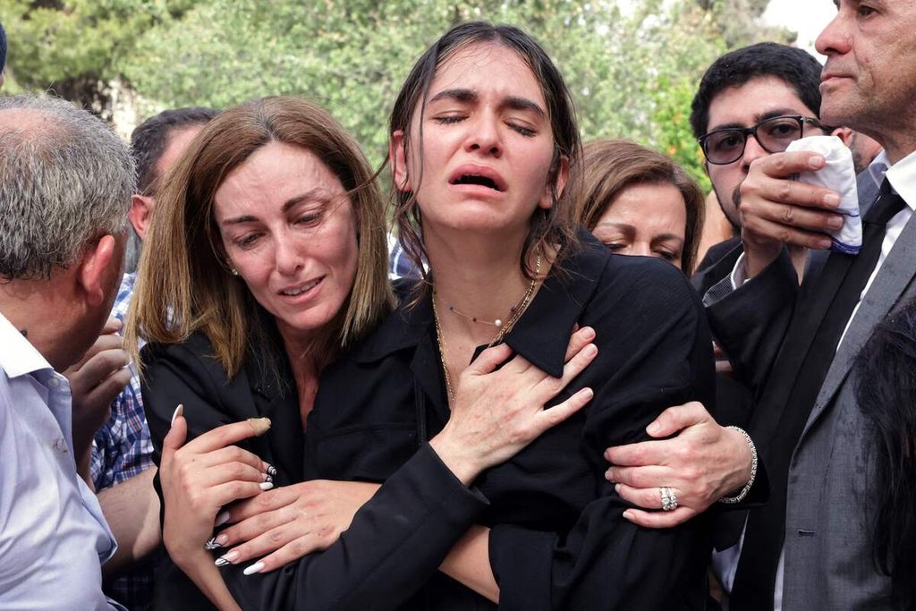 Para pelayat mengantarkan jenazah jurnalis veteran Al Jazeera, Shireen Abu Akleh, ke tempat pemakaman dalam upacara di Jerusalem timur, Jumat (13/5/2022).  