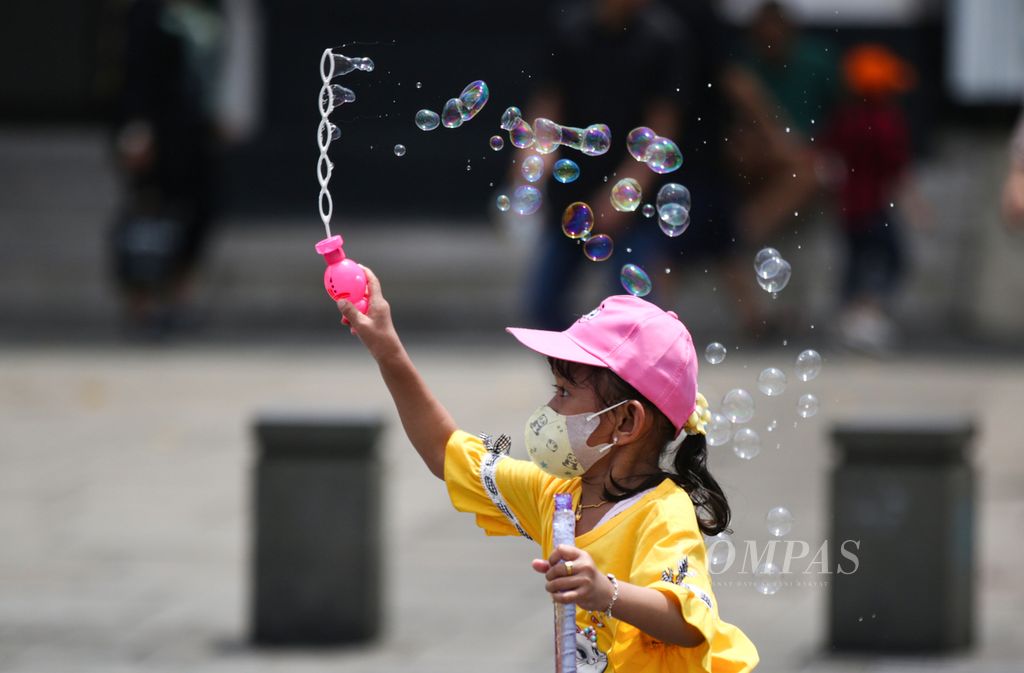 Seorang anak bermain gelembung sabun saat berkunjung ke kawasan wisata Kota Tua, Jakarta, Jumat (12/4/2024).  