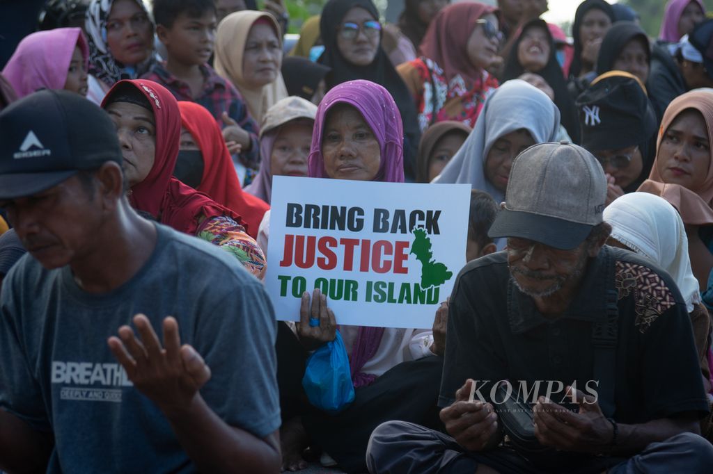 Warga memegang poster saat doa bersama di Jembatan Barelang IV, Pulau Rempang, Batam, Kepulauan Riau, Sabtu (7/9/2024). 