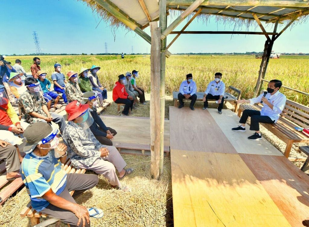 President Joko Widodo talks with farmers in Wanasari Village, Indramayu Regency, West Java, on Wednesday (21/4/2021).