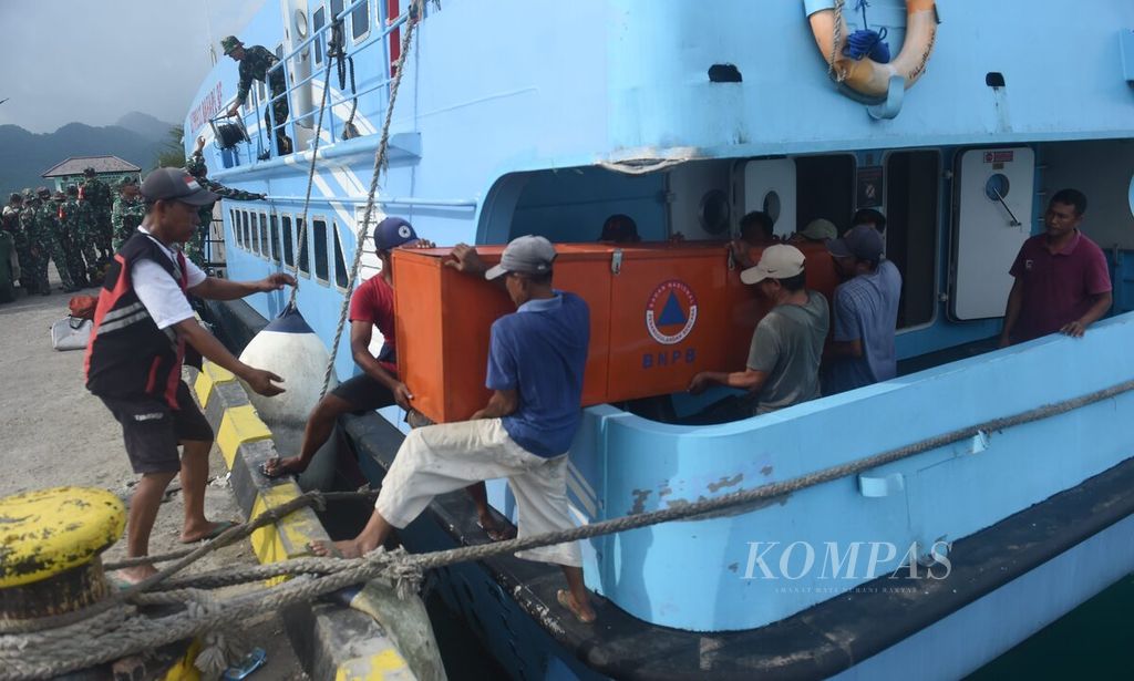 Pekerja menurunkan paket bantuan BNPB dari Kapal Cepat Express Bahari dari Gresik di Pelabuhan Pulau Bawean, Kabupaten Gresik, Jawa Timur, Senin (25/3/2024). 