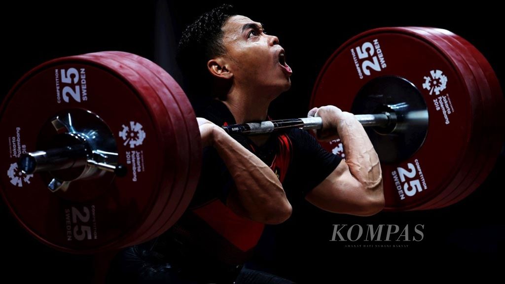 Atlet angkat besi Eko Yuli Irawan saat beraksi dalam nomor 62 kilogram putra cabang angkat besi dalam Asian Games 2018 di Jakarta. Eko memastikan diri tampil di Olimpiade Paris 2024.