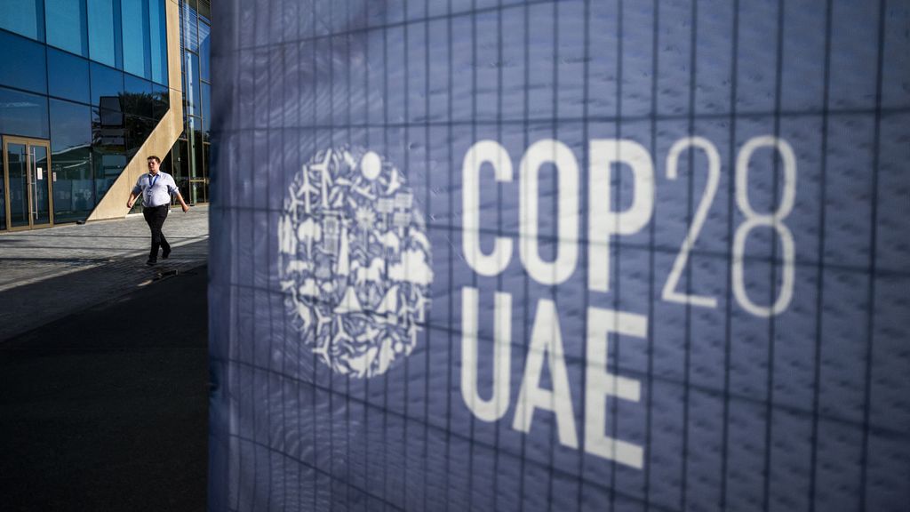 Seorang pria berjalan melewati tanda COP28 di lokasi Konvensi Kerangka Kerja Perubahan Iklim PBB di Dubai, Uni Emirat Arab, 30 November 2023. 