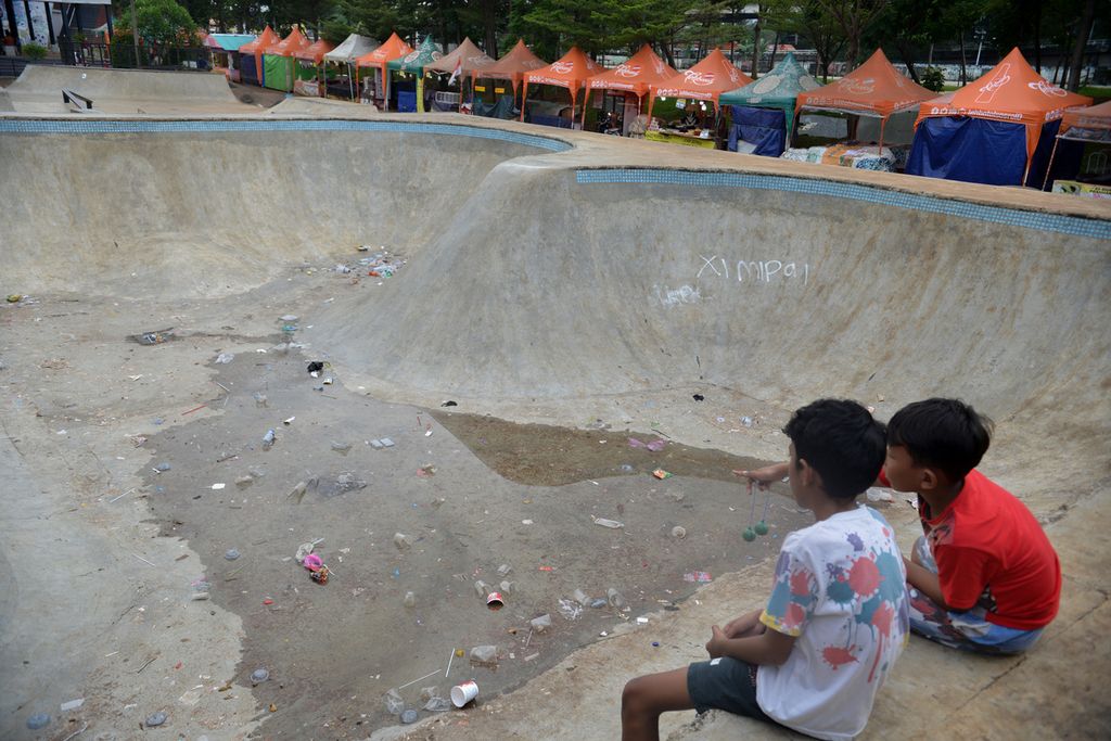 Sejumlah anak duduk di atas arena pul <i>skateboard</i> yang dikotori sampah di kawasan RPTRA dan RTH Kalijodo, Jakarta, Senin (2/1/2023). Setelah diresmikan pada 2017 silam, Ruang Publik Terpadu Ramah Anak (RPTRA) dan Ruang Terbuka Hijau (RTH) Kalijodo kini tampak kurang terawat. 
