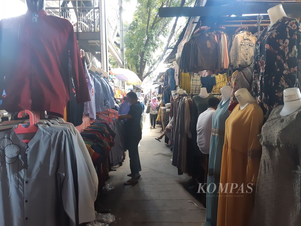 Seorang pedagang pakaian di Pasar Tanah Abang, Jakarta Pusat, Senin (4/4/2022). Di awal Ramadhan, omzet pedagang di pasar ini sudah menunjukan peningkatan. Kondisi ini ditengarai lantaran adanya pelonggaran protokol kesehatan jelang Idul Fitri.