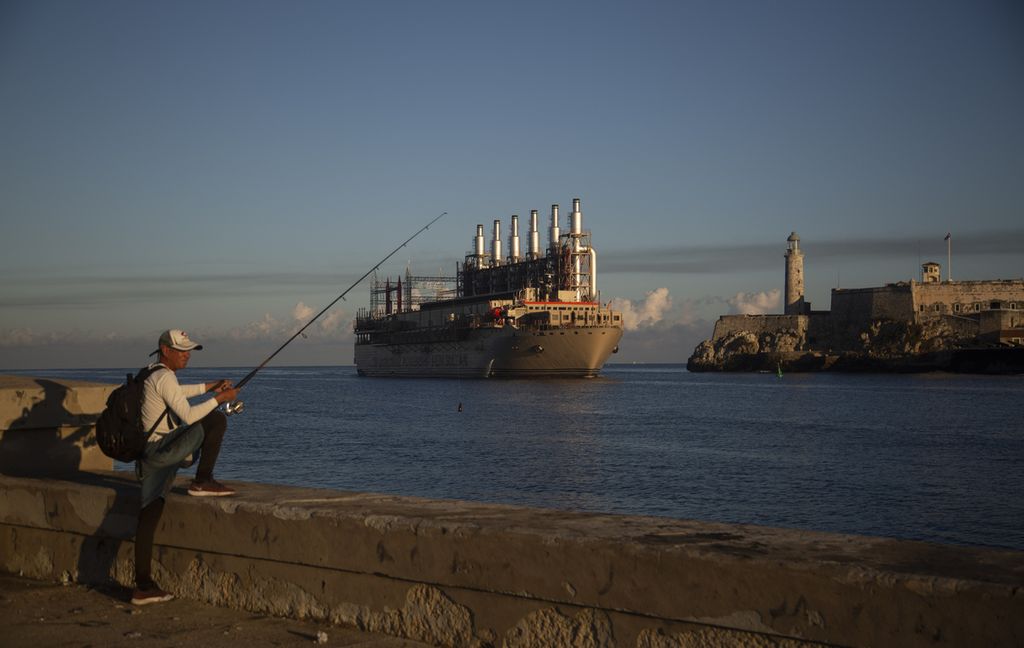 Nelayan memancing di tembok laut Malecon saat kapal berbendera Turki, Karadeniz Irem Sultan, tiba di Teluk Havana di Kuba, 15 November 2022. 