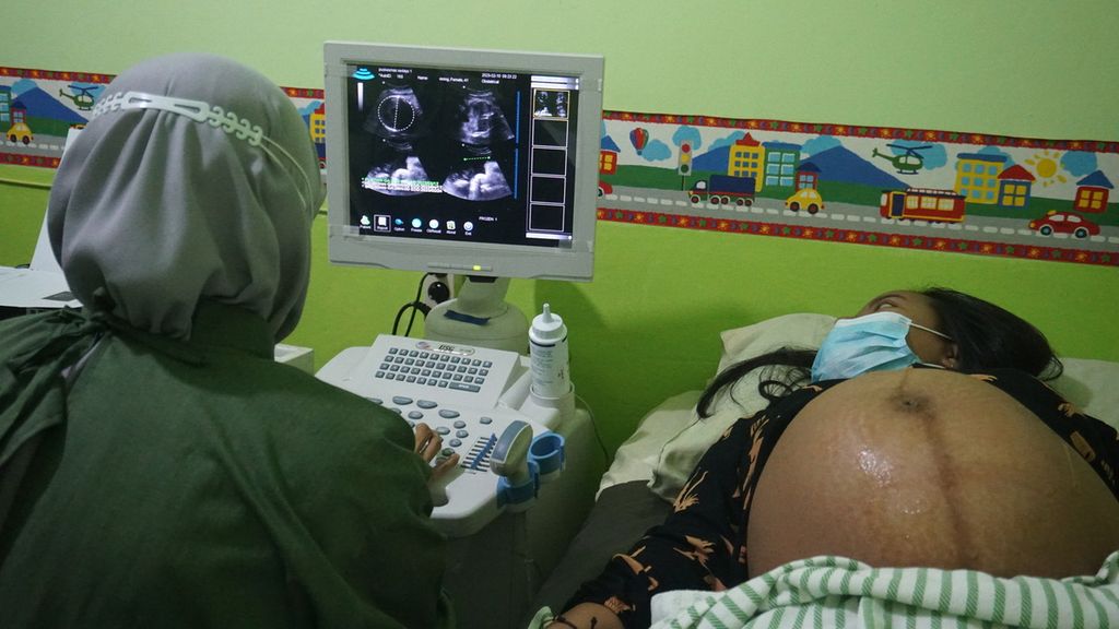 Nining Pujiastuti (41) menatap layar dari hasil pemeriksaan USG (ultrasonografi) yang dilakukan di Puskesmas Sedayu 1, Bantul, Yogyakarta, Jumat (10/2/2023). Pemeriksaan USG amat penting bagi ibu hamil untuk mendeteksi dini adanya gangguan pada kehamilan yang dapat menyebabkan kematian ibu dan bayi. 