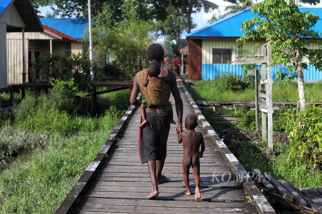 Elias Besap menggendong anaknya, Yohakim Ber (3), yang menderita gizi buruk, tuberkulosis, dan<i> prolaps rectum</i> di Kampung Er, Distrik Sawaerma, Kabupaten Asmat, Papua, pertengahan Oktober 2021. 