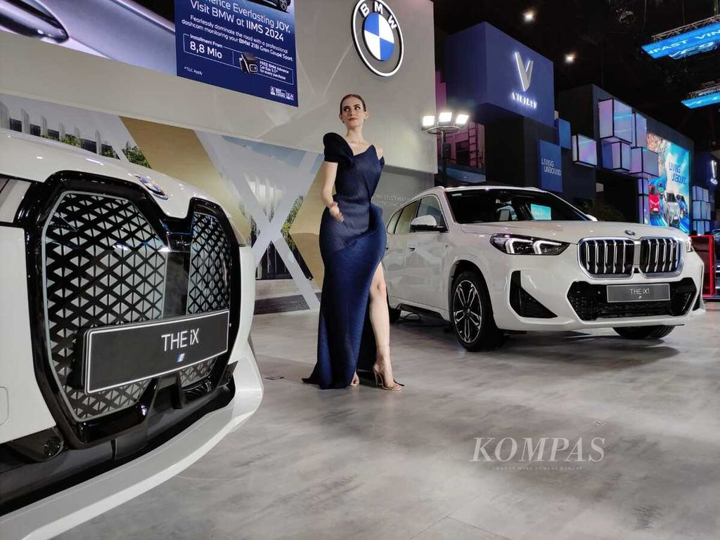 Seorang model bergaya di antara mobil-mobil terbaru BMW dalam Indonesia International Motor Show di Jakarta, Kamis (15/2/2024).