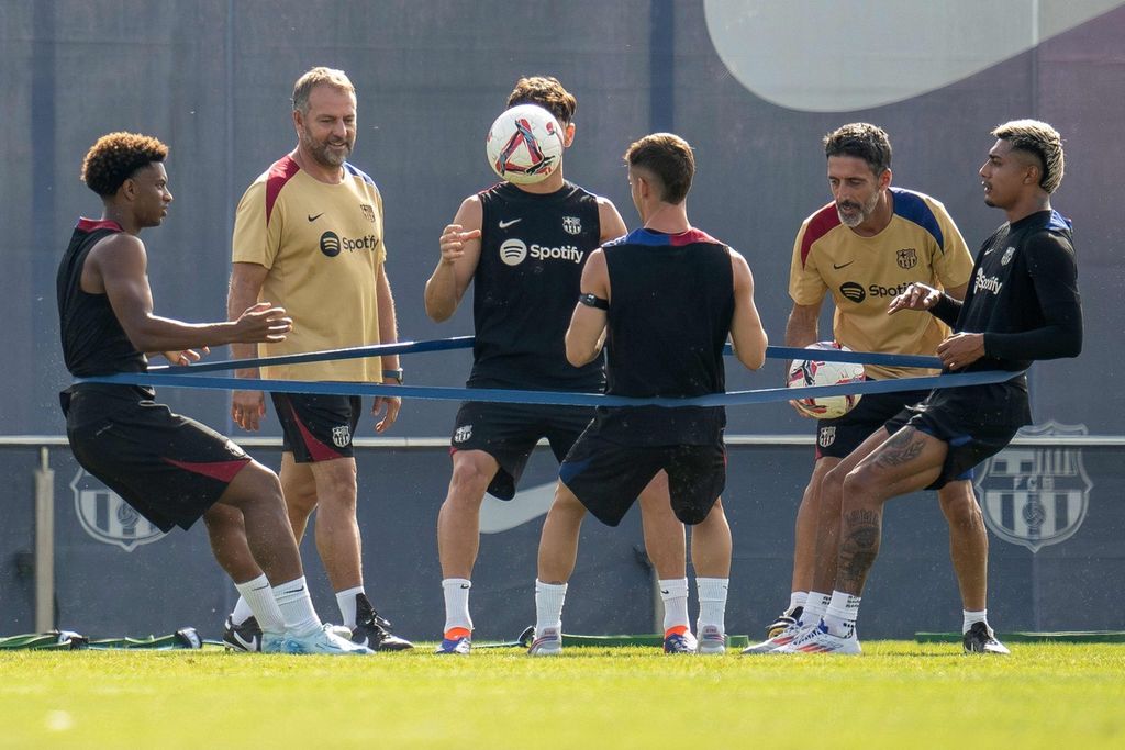 Pelatih Barcelona Hansi Flick (kedua dari kiri) mengawasi para pemainnya saat sesi latihan perdana di lapangan latihan Joan Gamper, Sant Joan Despi, Barcelona, 19 Juli 2024.