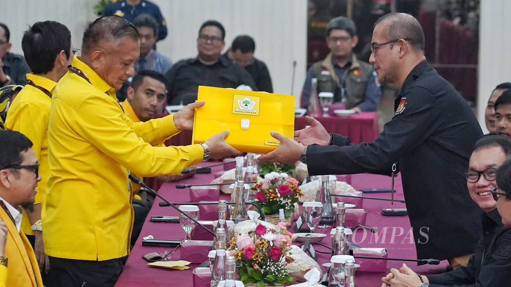 Sekertaris Jenderal Partai Golkar Lodewijk Freidich Paulus (kiri) menyerahkan berkas pengajuan bakal calon anggota DPR dari partainya kepada Ketua KPU Hasyim Asyari (kanan) di Kantor Komisi Pemilihan Umum, Jakarta, Minggu (14/5/2023).