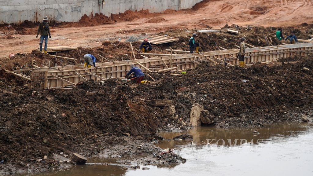 Pekerja dalam pembangunan turap Kali Ciliwung di Cawang, Jakarta Timur, Jumat (25/11/2022). Pemasangan turap sepanjang 800 meter di kawasan tersebut untuk normalisasi sungai dan antisipasi banjir yang kerap melanda kawasan tersebut. 