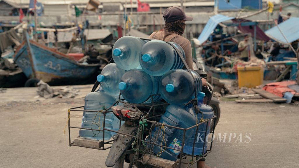 Pekerja membawa galon air kemasan berbahan polikarbonat di Cilincing, Jakarta Utara,  September 2022. Air kemasan galon guna ulang yang tercemar Bisphenol A atau BPA dikhawatirkan mengancam kesehatan masyarakat. Badan Pengawas Obat dan Makanan menemukan BPA dalam air minum dalam kemasan (AMDK) polikarbonat melebihi ambang batas 0,6 bagian per sejuta (ppm) per liter di enam daerah. 
