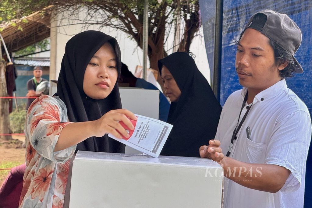 Petugas mendampingi warga saat memasukkan surat suara usai mencoblos pada pemungutan suara ulang di Tempat Pemungutan Suara (TPS) 12 Desa Sigar Penjalin, Kecamatan Tanjung, Kabupaten Lombok Utara, Nusa Tenggara Barat, Rabu (21/2/2024).