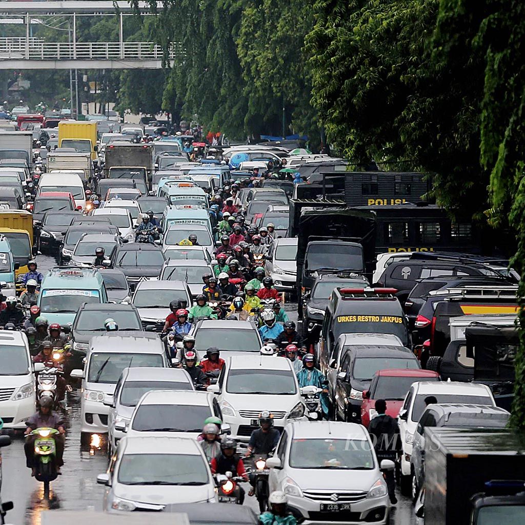Kendaraan terjebak macet saat melalui Jalan Kramat Raya, Jakarta, setelah hujan, Kamis (18/1). Banyaknya genangan dan kendaraan yang parkir di tepi jalan untuk berteduh menyebabkan lalu lintas tersendat.