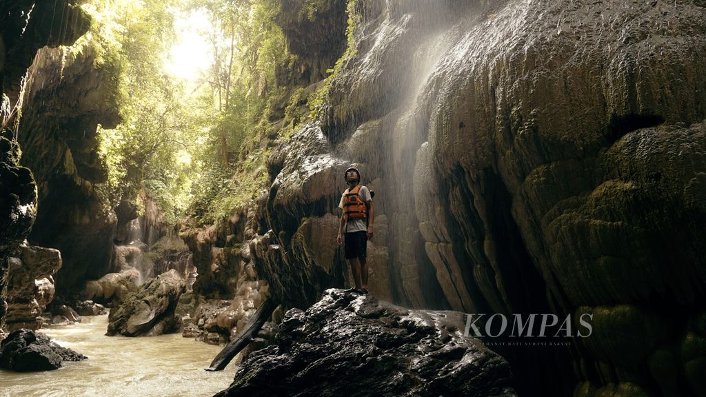 Wisatawan mengagumi batuan yang mengelilingi Sungai Cijulang di Green Canyon, Kabupaten Pangandaran, Jawa Barat, Senin (8/8/2022). Penamaan Green Canyon tersebut karena saat kemarau warna air Sungai Cijulang yang mengalir di antara tebing karang terlihat berwarna hijau bening. Wisatawan bisa memacu adrenalin dengan mengikuti <i>body rafting,</i> yakni aktivitas perorangan mengarungi sungai dengan rompi pelampung dan helm pengaman. Aktivitas Green Canyon (Cukang Taneuh) dibatasi maksimal 500 tiket dalam sehari.