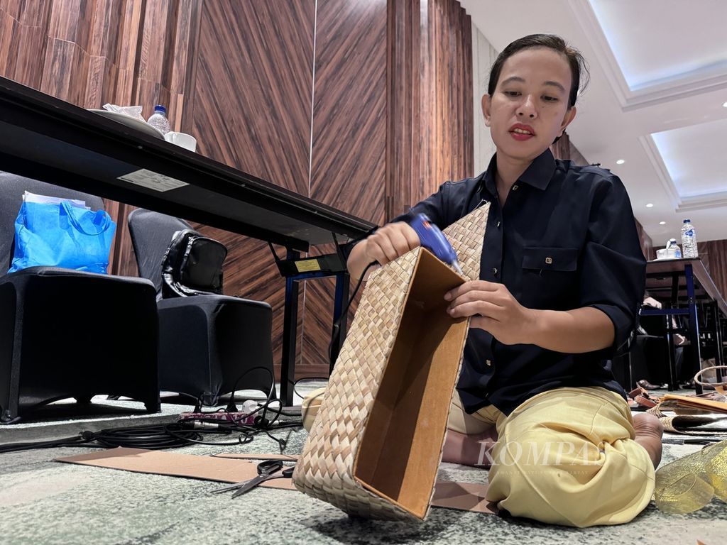 Desak (39), salah satu peserta, melapisi kotak hamper buatannya dengan anyaman pandan pada Pelatihan Pembuatan Suvenir Tahap 1 Dinas Pariwisata Kota Mataram di Hotel Lombok Astoria, Mataram, Nusa Tenggara Barat, Selasa (7/5/2024). 
