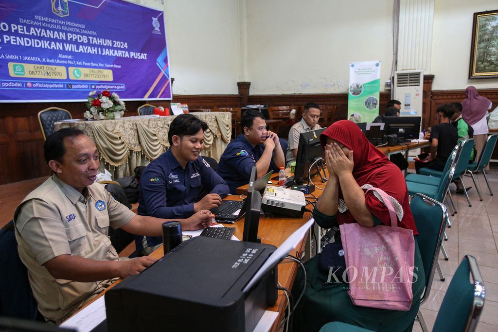 Ekspresi orangtua siswa saat mengeluhkan masalahnya kepada petugas di posko layanan PPDB di SMKN 1 Jakarta, Selasa (11/6/2024). 