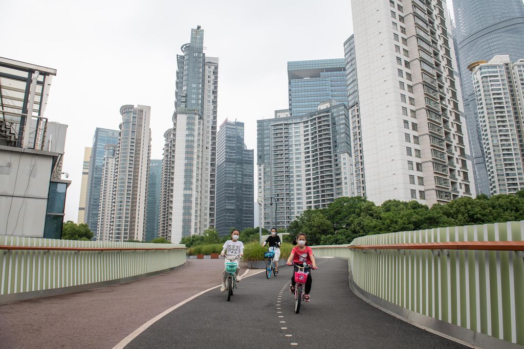 Warga bersepeda di sepanjang tepi Sungai Huangpu saat kebijakan penguncian wilayah di Distrik Pudong, Shanghai, China, mulai dilonggarkan, 30 Mei 2022. 