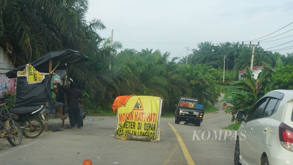 Sebuah papan peringatan kepada pengendara yang melewati jalan lintas timur Sumatera di Kabupaten Indragiri Hilir, Riau, Senin (2/1/2022). Jalan ini menjadi jalur penghubung antarprovinsi di Sumatera. Hanya, beberapa kendala ditemui, seperti jalan rusak, bergelombang, serta longsor di sejumlah sisi.