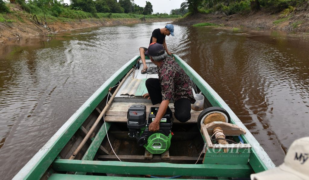 Warga menggunakan perahu menyusuri Sungai Berembang yang bermuara ke Sungai Batanghari di Desa Danau Lamo, Kecamatan Maro Sebo, Muaro Jambi, Jambi, Rabu (10/7/2024).