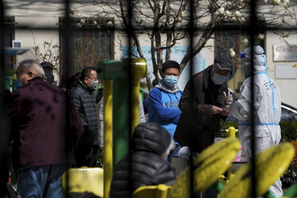 Warga antre tes Covid-19 untuk pelacakan kasus menyusul kasus Covid-19 yang terdeteksi di kawasan tersebut di Beijing, China. Senin (28/3/2022). Pemerintah China memulai <i>lockdown </i>terbesar dalam dua tahun pandemi Covid-19 untuk mengendalikan wabah yang meluas di Shanghai. 