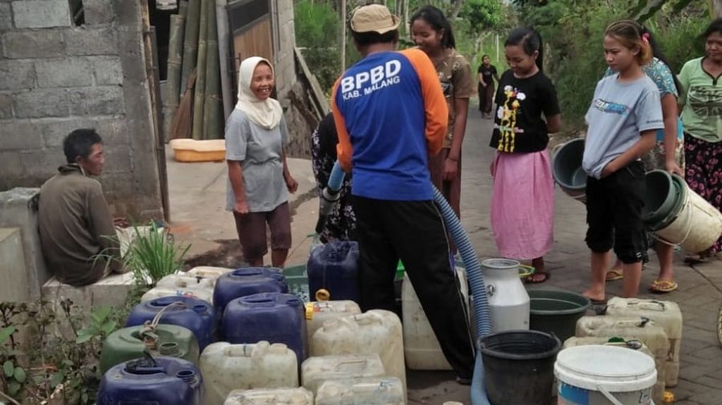 Petugas Badan Penanggulangan Bencana Daerah Kabupaten Malang, Jawa Timur, melakukan pembagian air bersih kepada warga di Desa Klampok, Kecamatan Singosari, Minggu (10/9/2023).