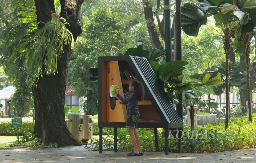 Seorang anak membaca buku yang diambil dari lemari buku Bookhive di Taman Suropati, Menteng, Jakarta Pusat, Senin (24/4/2023). Lemari buku di taman itu mempermudah masyarakat mengakses bahan bacaan sehingga diharapkan meningkatkan literasi.