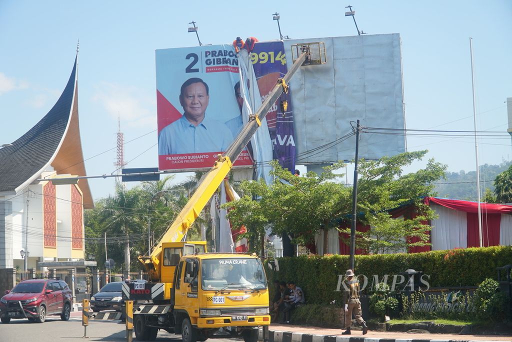 Petugas gabungan yang dikoordinasi oleh Bawaslu Kota Padang mencopot alat peraga kampanye (APK) di Jalan Jenderal Sudirman, Kota Padang, Sumatera Barat, pada hari perdana masa tenang pemilu, Minggu (11/2/2024). 