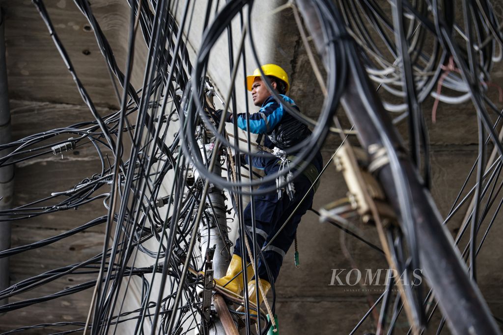 Petugas lapangan Perusahaan Listrik Negara memasang jaringan kabel listrik di kawasan Kebayoran Lama, Jakarta Selatan, Selasa (17/1/2023).