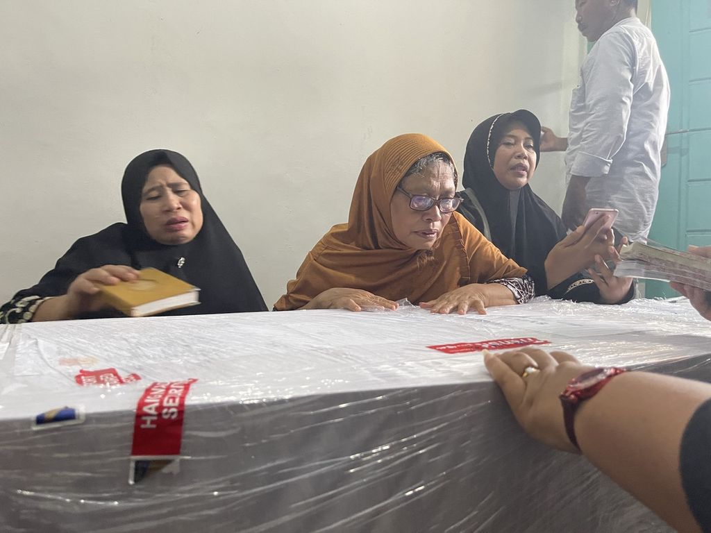 Sukmawati (60), ibu kandung Syech Mulachela (38), pekerja migran Indonesia yang meninggal dalam kecelakaan kapal di perairan Johor, berdoa di dekat peti jenazah anaknya di Kampung Bhineka, Desa Kopang, Kecamatan Kopang, Jumat (24/12/2021). Dari tujuh jenazah yang teridentifikasi asal Lombok, tiga orang telah dipulangkan Jumat itu dan empat lainnya direncanakan pada Sabtu keesokan harinya.