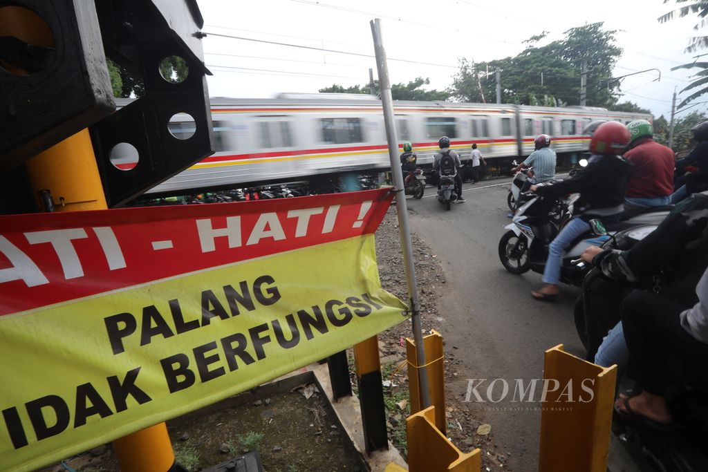 Spanduk peringatan bagi pengguna jalan terpasang di pintu pelintasan kereta di kawasan Bumi Bintaro Permai, Pesanggrahan, Jakarta Selatan, Rabu (19/2/2020). 