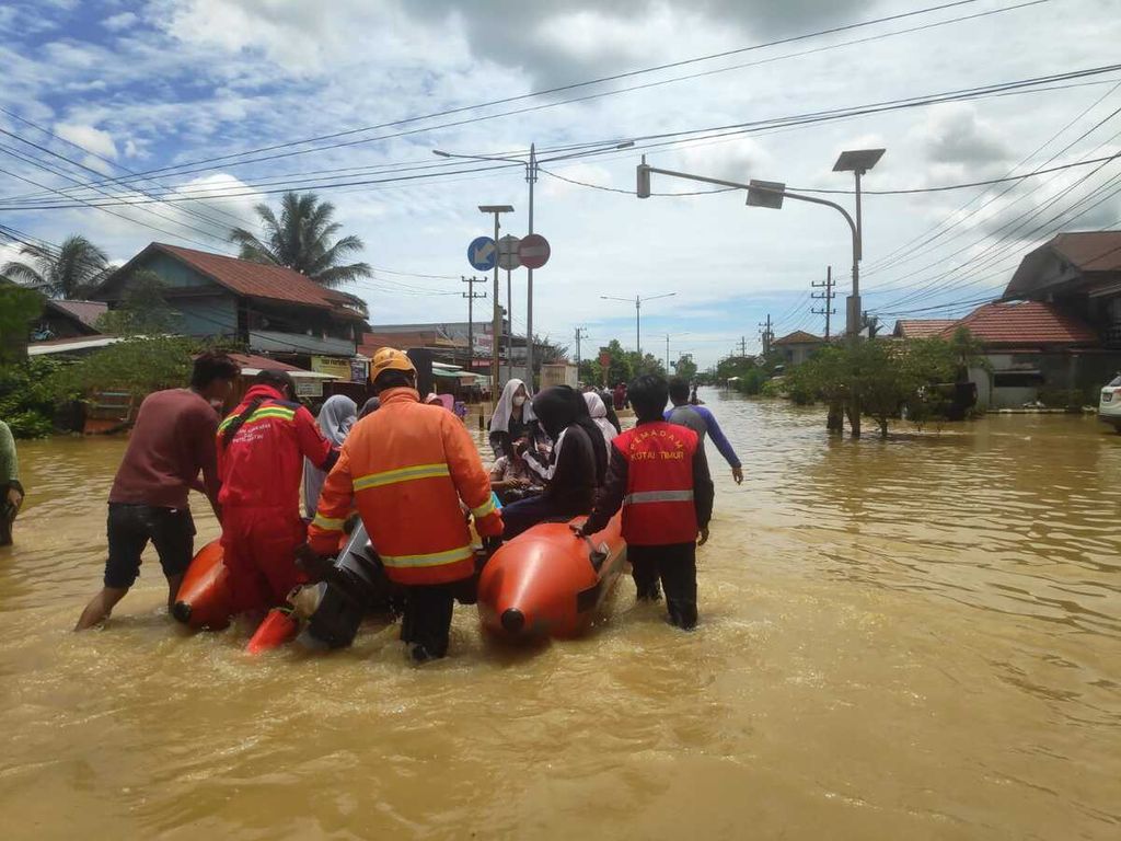 Tim gabungan mengevakuasi warga yang terdampak banjir di Kutai Timur, Kalimantan Timur, Minggu (20/3/2022). Sedikirnya 3.900 keluarga terdampak banjir yang belum surut hingga Senin (21/3/2022). 