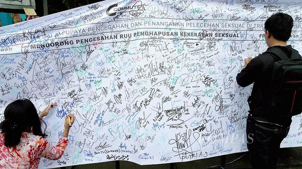 Peserta aksi membubuhkan tanda tangan ke spanduk sebagai dukungan pengesahan RUU Penghapusan Kekerasan Seksual saat Women's March di Taman Aspirasi, Kawasan Monumen Nasional, Jakarta, Sabtu (3/3/2018). 