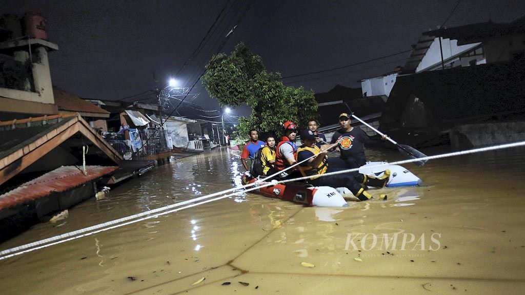 Tim pemadam kebakaran Jakarta Selatan mengevakuasi warga dari rumahnya yang terendam banjir luapan Sungai Ciliwung di Kelurahan Rawa Jati, Kecamatan Pancoran, Jakarta Selatan, Senin (5/2) malam.