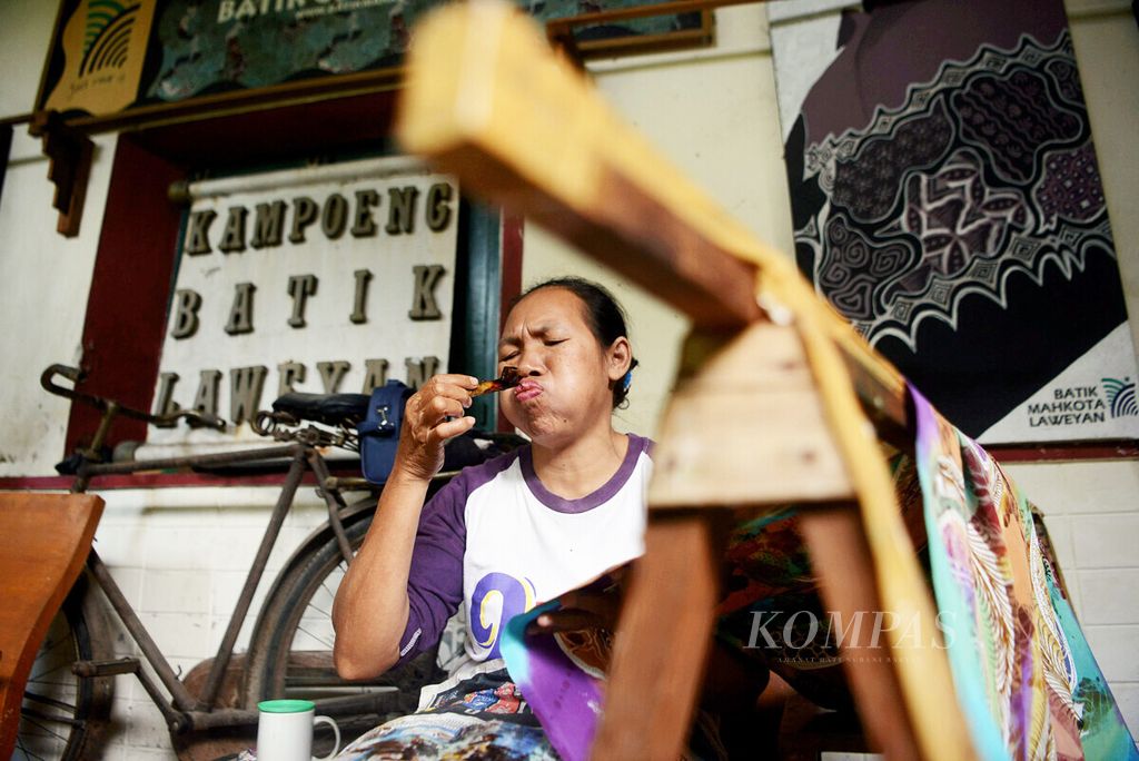 Ngatmi (51) menyelesaikan pembuatan batik di tempat usaha Batik Mahkota di sentra batik Laweyan, Solo, Jawa Tengah, Rabu (15/7/2020). Beragam motif batik baru terus dikembangkan di kawasan itu sebagai bagian dari upaya melestarikan batik sebagai warisan budaya.