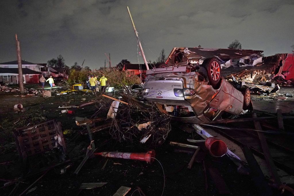 Sebuah mobil terbalik akibat empasan tornado di Arabi, Louisiana, Amerika Serikat, 22 Maret 2022. Laporan Perserikatan Bangsa-Bangsa yang dirilis pada Senin (25/4/2022) menyebutkan, jumlah bencana alam akibat perubahan iklim di dunia akan meningkat menjadi sekitar 560 kali per tahun mulai 2030. 