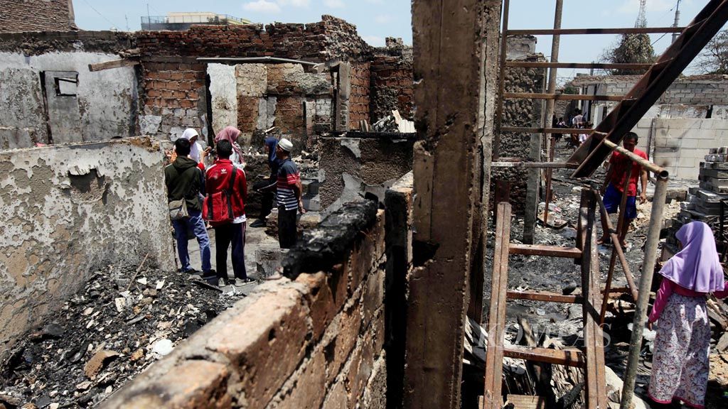 Warga melihat  lokasi bekas kebakaran di Kelurahan Kembangan Utara, Kembangan, Jakarta Barat, Jumat (30/3). Kebakaran tersebut menghanguskan 117 rumah dan menyebabkan dua warga meninggal. 