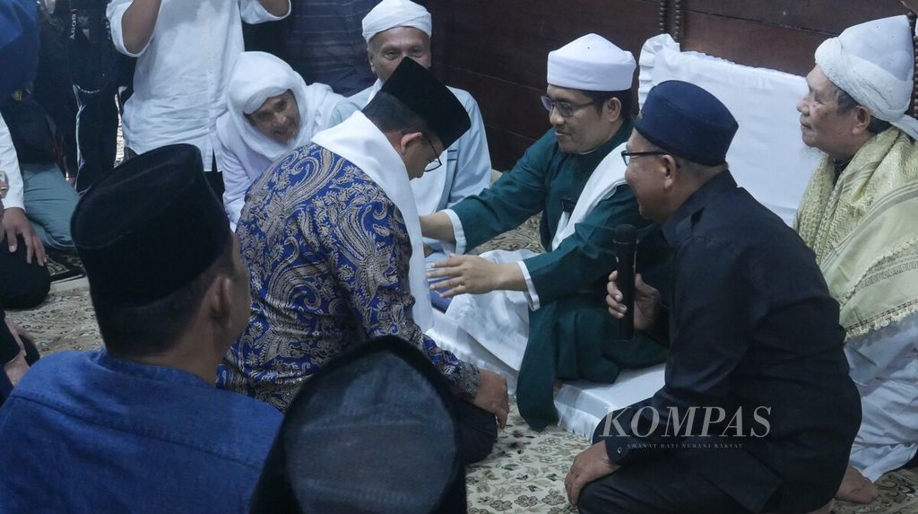 Tuan Guru Babussalam, Sheikh Zikmal Fuad (kanan) mengenakan sorban kepada bakal calon presiden dari Partai Nasdem, Anies Baswedan (kiri), di Langkat, Sumatera Utara, Sabtu (5/11/2022). Anies meminta nasihat kepada Sheikh Zikmal sebagai calon presiden dari Partai Nasdem.