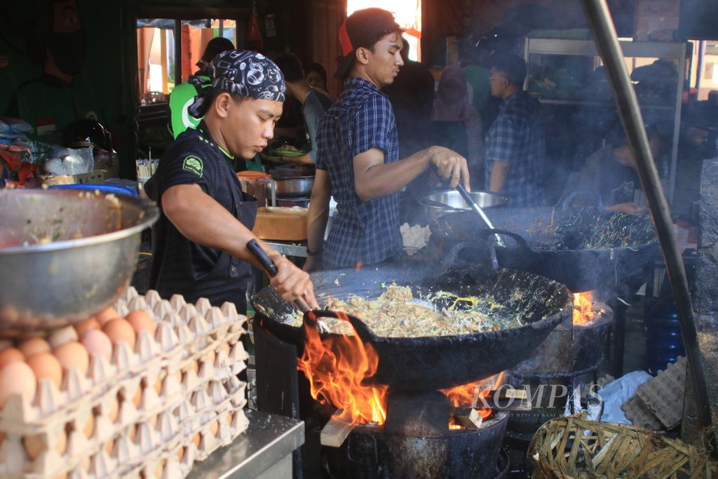 Juru masak menggoreng mi balap dengan kuali besar dan kayu bakar di Mi Balap Mail di Jalan Krakatau, Medan, Sumatera Utara, Jumat (3/11/2023). 