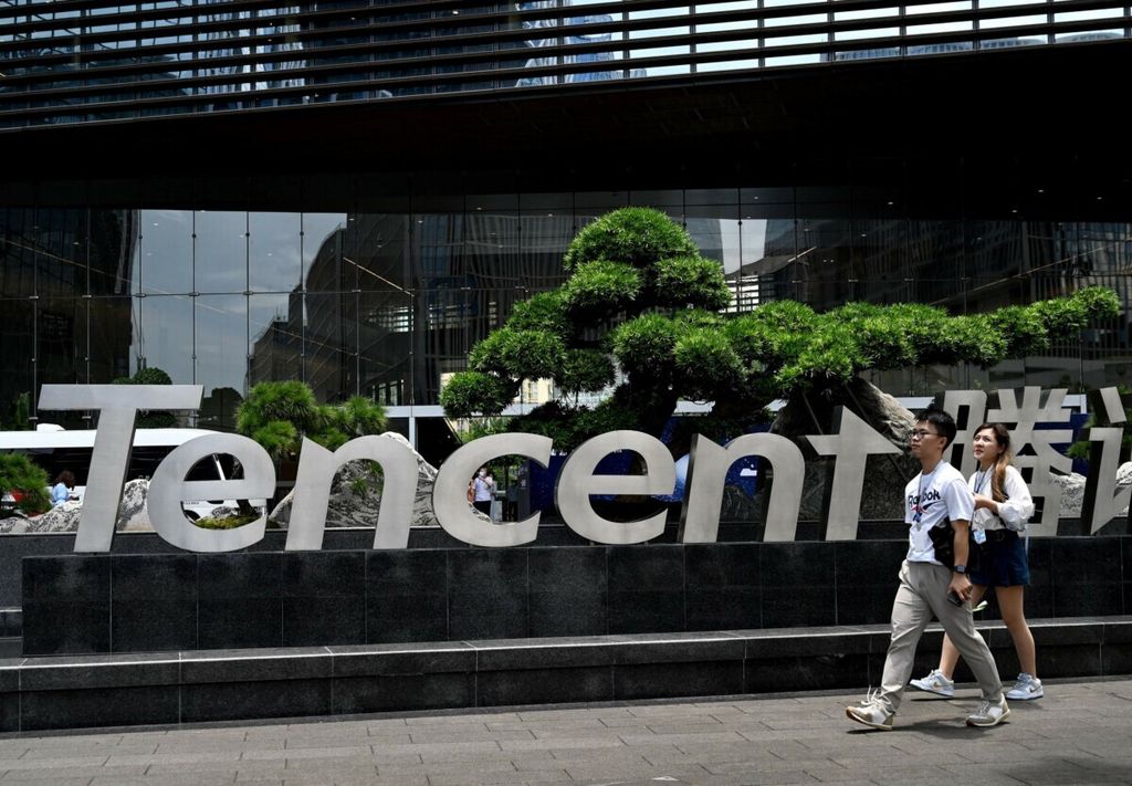 Warga berjalan di depan kantor perusahaan teknologi China, Tencent, di Shenzhen, 28 Mei 2021. Pemerintah China membuat sejumlah kebijakan untuk menekan perusahaan teknologi di negara tersebut.