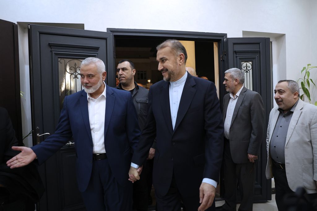 Menteri Luar Negeri Iran Hossein Amirabdollahian (tengah) disambut pemimpin Hamas, Ismail Haniyeh (kiri), dalam pertemuan mereka di Doha, Qatar, Rabu (20/12/2023). 