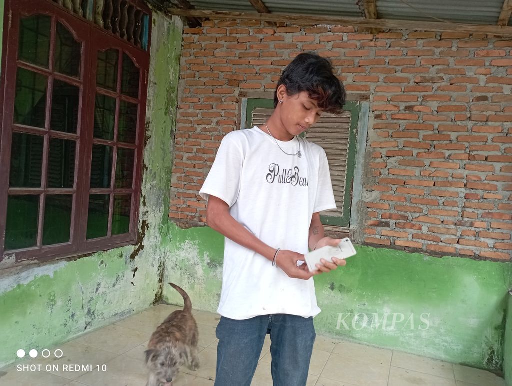 Aris Setiawan (16) beraktivitas di rumahnya di Desa Saentis, Kecamatan Percut Sei Tuan, Kabupaten Deli Serdang, Sumatera Utara, Minggu (27/2/2022). Aris sudah empat tahun putus sekolah karena kesulitan ekonomi keluarga.