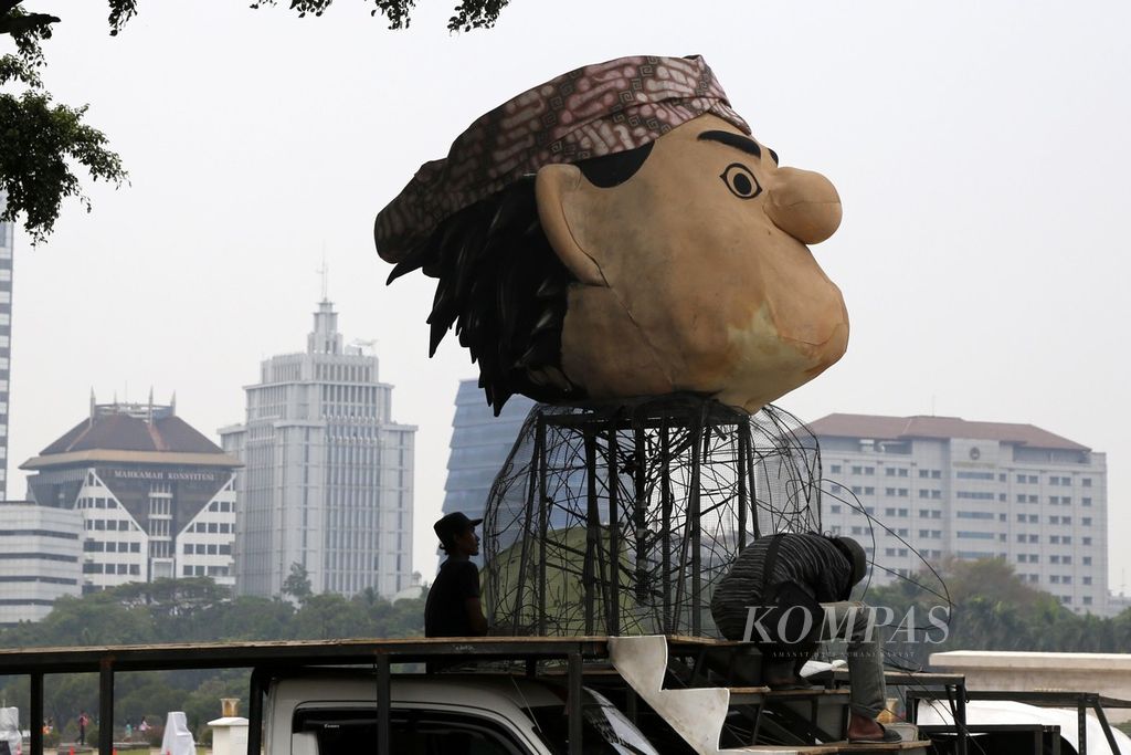 Pekerja menyelesaikan dekorasi untuk mobil hias yang akan digunakan pada acara parade Jakarnaval pada malam tahun baru di Monas, Jakarta, Rabu (27/12/2023). 