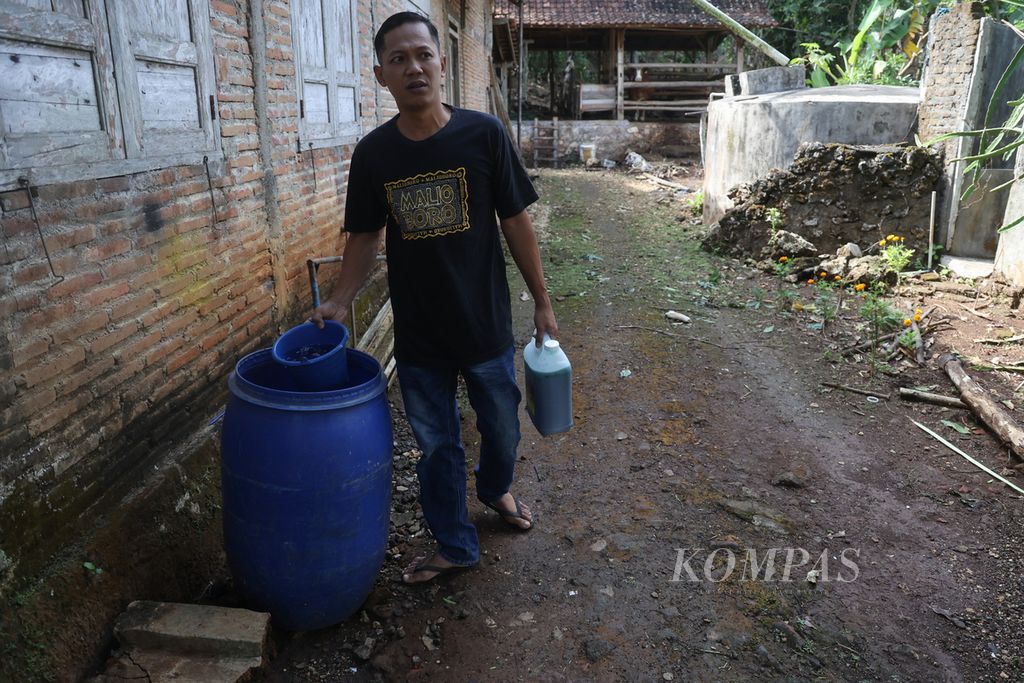 Kepala Dusun Jati Sugeng Ari Susanto (38) bersiap menyiramkan air yang dicampur formalin untuk mencegah penularan antraks di kandang sapi miliknya di Dusun Jati, Desa Candirejo, Semanu, Gunungkidul, DI Yogyakarta, Kamis (6/7/2023). 
