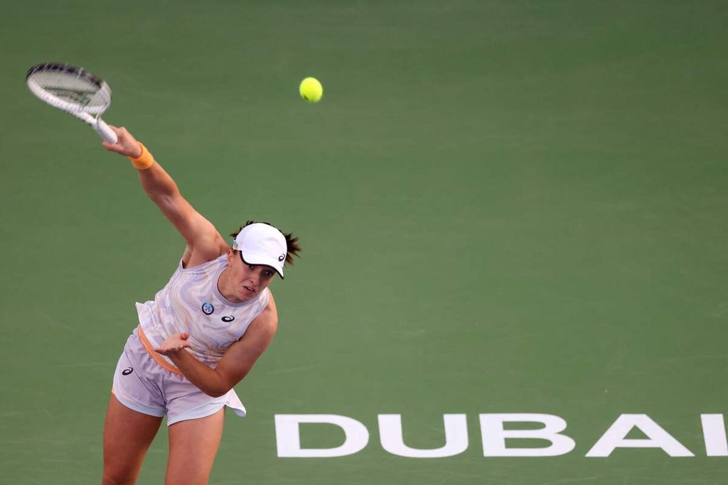 Petenis Polandia Iga Swiatek melakukan servis ke petenis AS Coco Gauff dalam semifinal turnamen WTA 1000 Dubai, Jumat (24/2/2023). Swiatek memenangi laga dengan skor 6-4, 6-2.