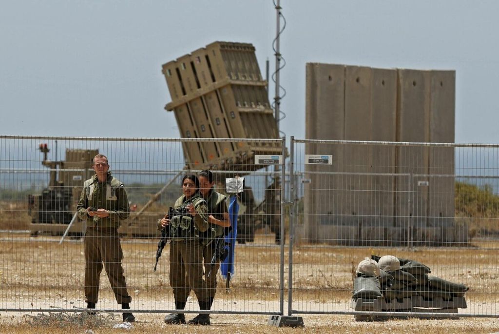 Tentara Israel berdiri di samping sistem pertahanan udara Iron Dome yang dipasang untuk mencegat roket yang diluncurkan dari Jalur Gaza, yang dikendalikan oleh gerakan Hamas, di atas kota Ashkelon di Israel selatan, pada 11 Mei 2021. 