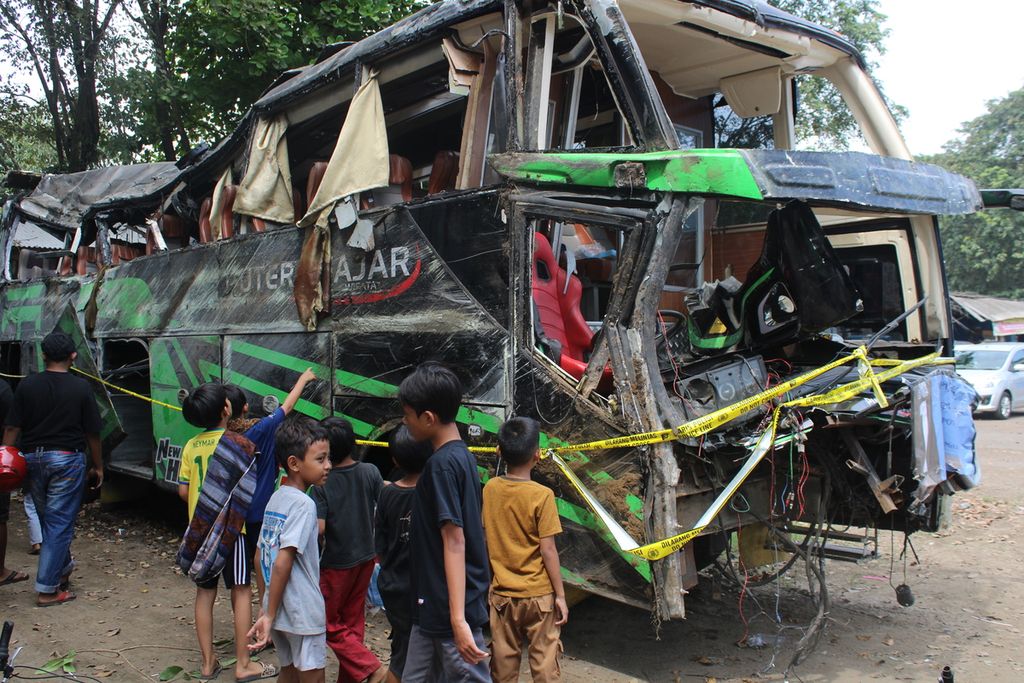 Beberapa anak mengamati bus yang rusak akibat kecelakaan yang diparkir di Terminal Subang, Jawa Barat, Minggu (12/5/2024). Bus bernomor polisi AD 7524 OG ini membawa rombongan dari SMK Lingga Kencana Depok dan terguling di perjalanan pada Sabtu (11/5/2024) petang dan menewaskan 11 orang.